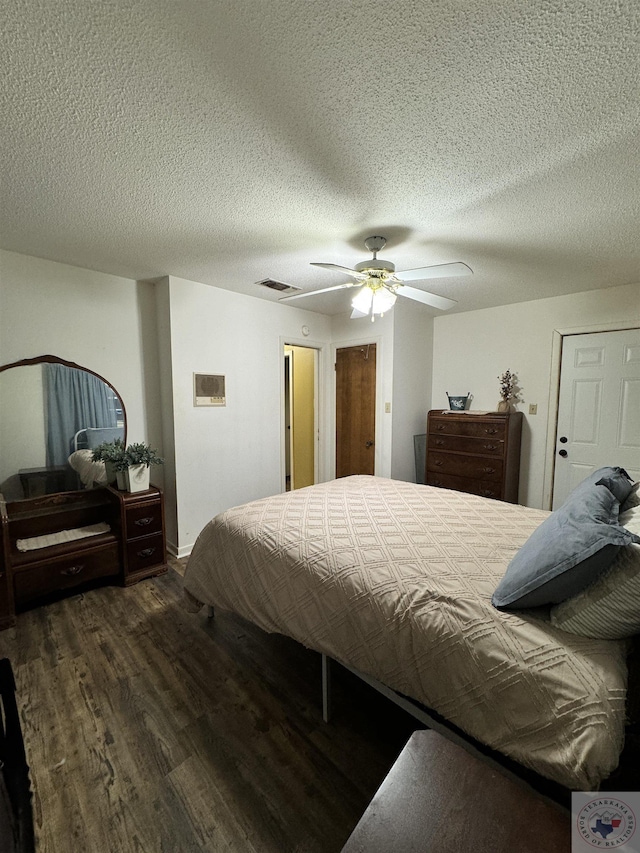 bedroom with a textured ceiling, dark hardwood / wood-style floors, and ceiling fan