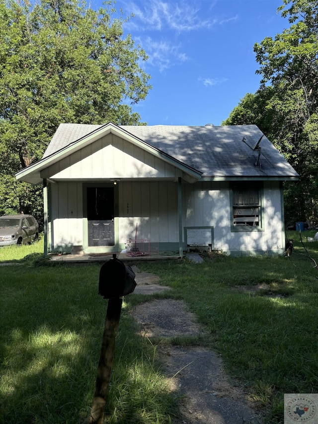 view of front of house featuring covered porch and a front lawn