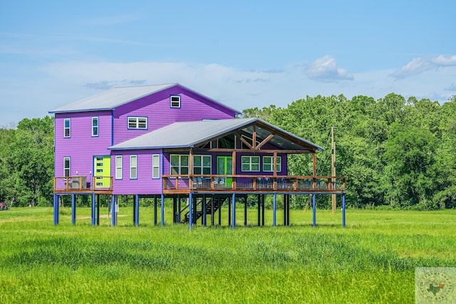 rear view of house featuring a deck and a lawn