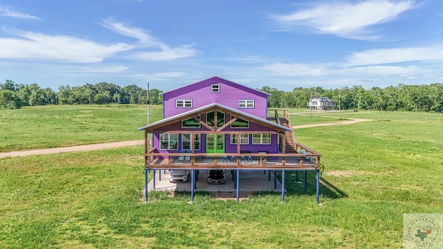 back of house featuring a wooden deck, a yard, and a rural view