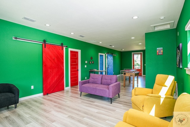 living room featuring light wood-type flooring and a barn door