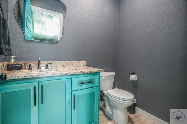 bathroom featuring hardwood / wood-style flooring, toilet, and vanity