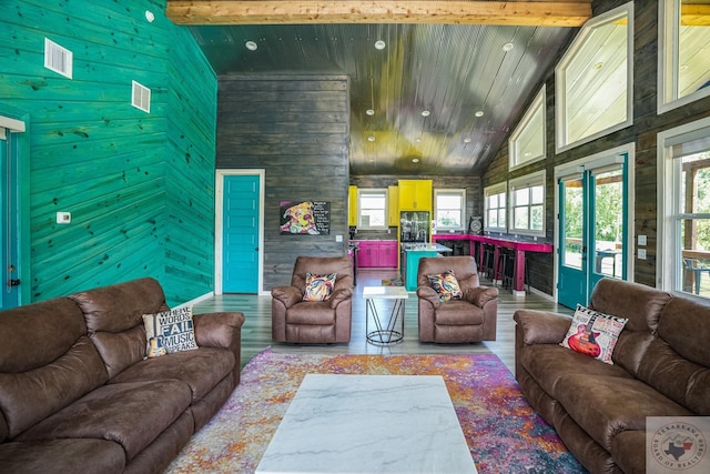 living room featuring hardwood / wood-style floors, a healthy amount of sunlight, beamed ceiling, and high vaulted ceiling