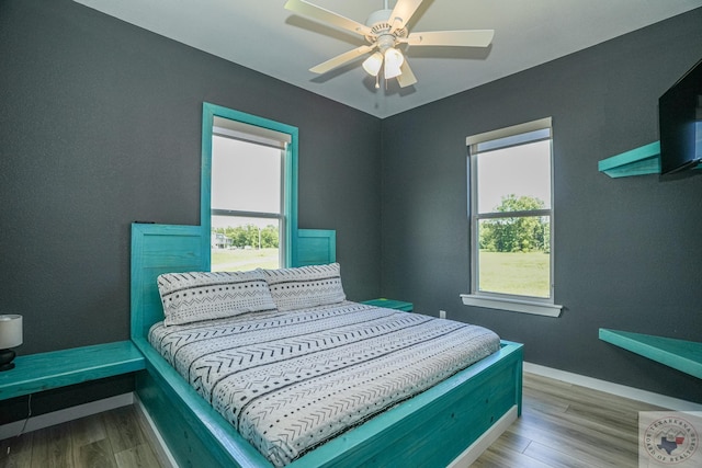 bedroom with ceiling fan and light hardwood / wood-style floors