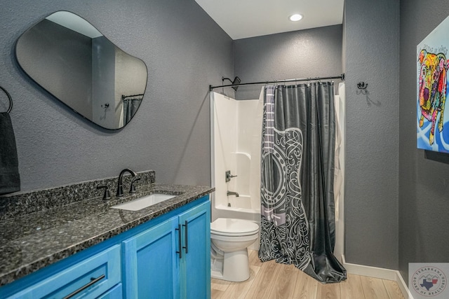 full bathroom with shower / bath combo with shower curtain, hardwood / wood-style flooring, toilet, and vanity