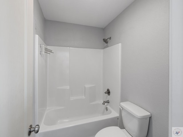 bathroom featuring tub / shower combination and toilet