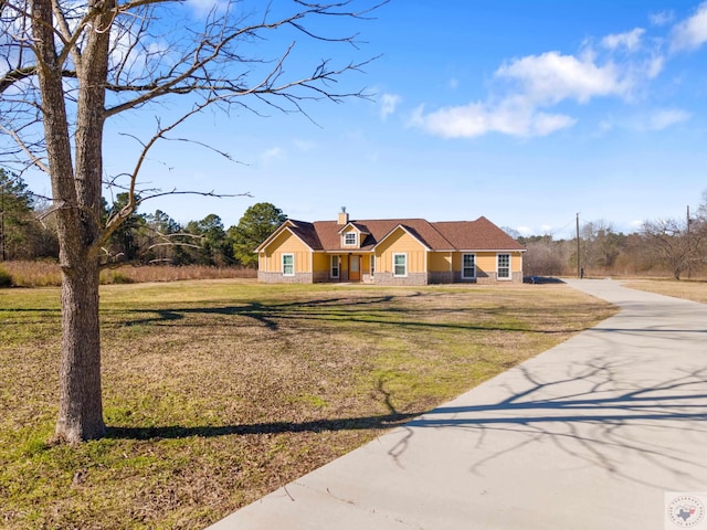 view of front of home with a chimney and a front lawn