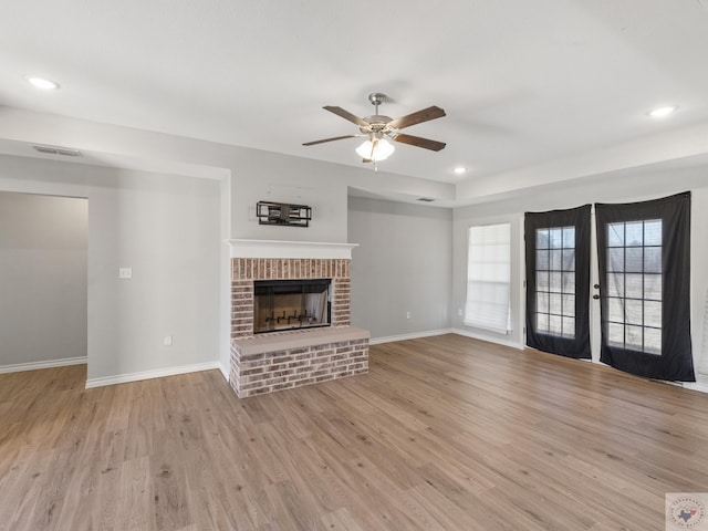 unfurnished living room featuring a fireplace, recessed lighting, light wood-style floors, a ceiling fan, and baseboards