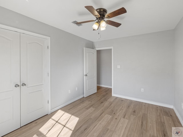 unfurnished bedroom featuring a closet, baseboards, visible vents, and light wood finished floors