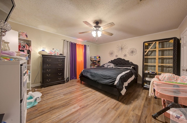 bedroom featuring ceiling fan, crown molding, a textured ceiling, and hardwood / wood-style flooring