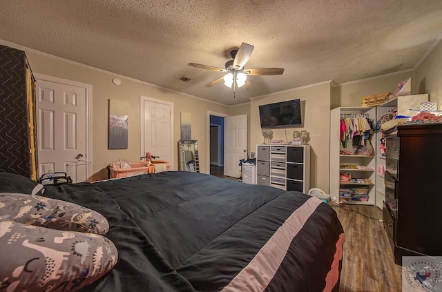 bedroom with ornamental molding, a textured ceiling, ceiling fan, and dark hardwood / wood-style flooring