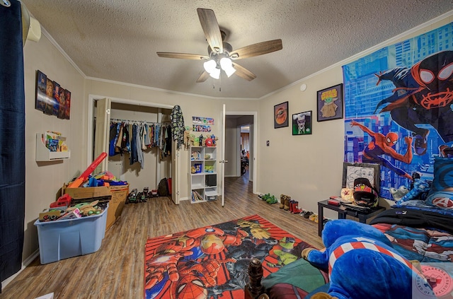 rec room featuring wood-type flooring, a textured ceiling, ceiling fan, and crown molding