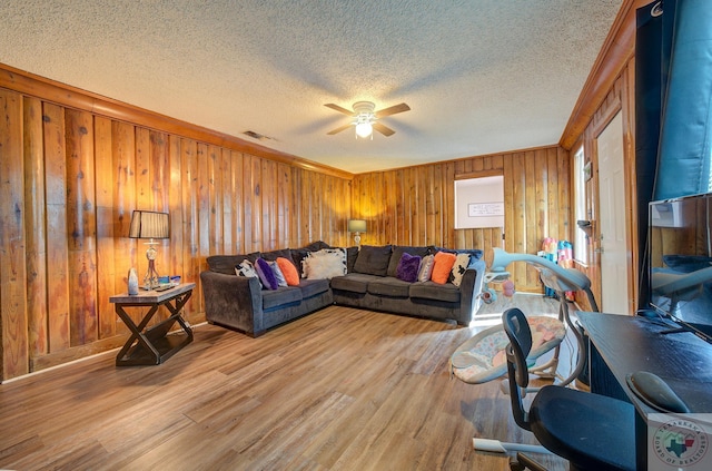 living room with ceiling fan, light hardwood / wood-style floors, and a textured ceiling