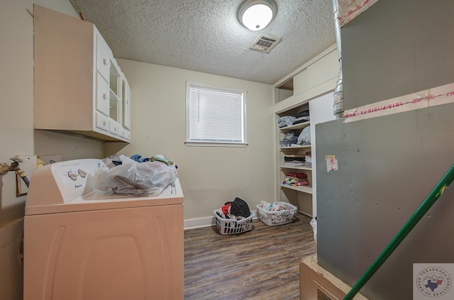 washroom with hardwood / wood-style flooring, a textured ceiling, and washer and dryer