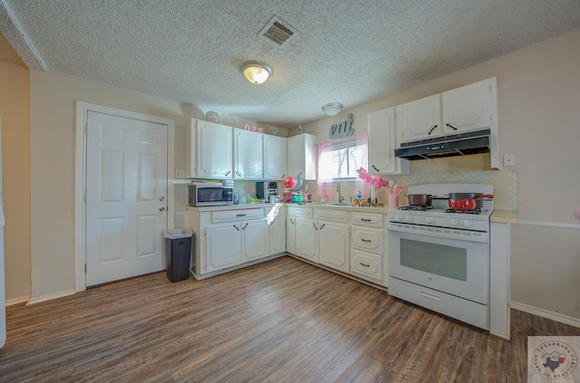 kitchen featuring dark wood-type flooring, a textured ceiling, white cabinets, and gas range gas stove