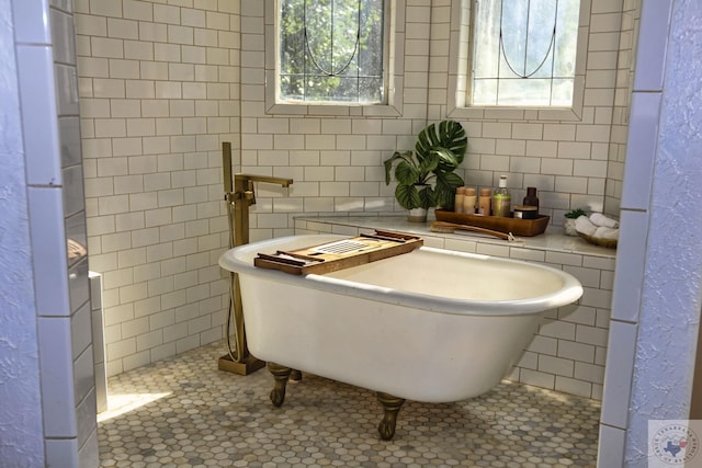 bathroom featuring a washtub, tile patterned floors, and a healthy amount of sunlight