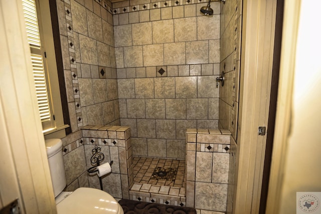 bathroom with tiled shower and toilet