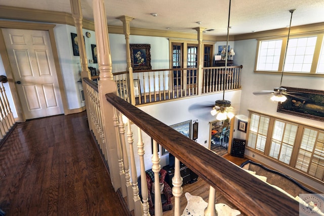 corridor with ornate columns, ornamental molding, dark hardwood / wood-style flooring, and a textured ceiling