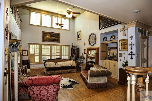 living room featuring wood-type flooring, a wealth of natural light, and a towering ceiling