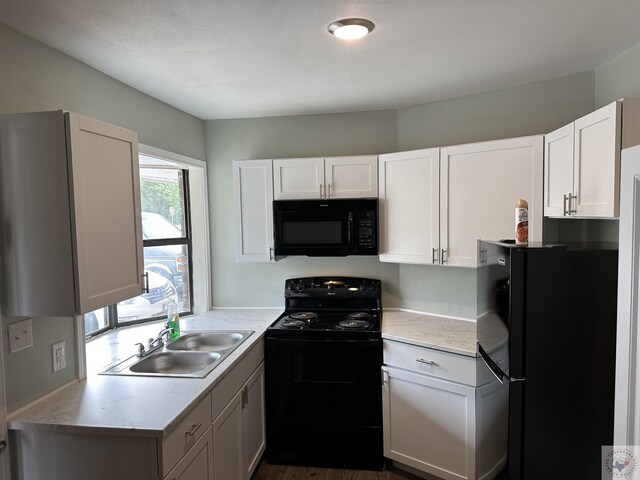 kitchen with dark hardwood / wood-style floors, sink, white cabinets, and black appliances