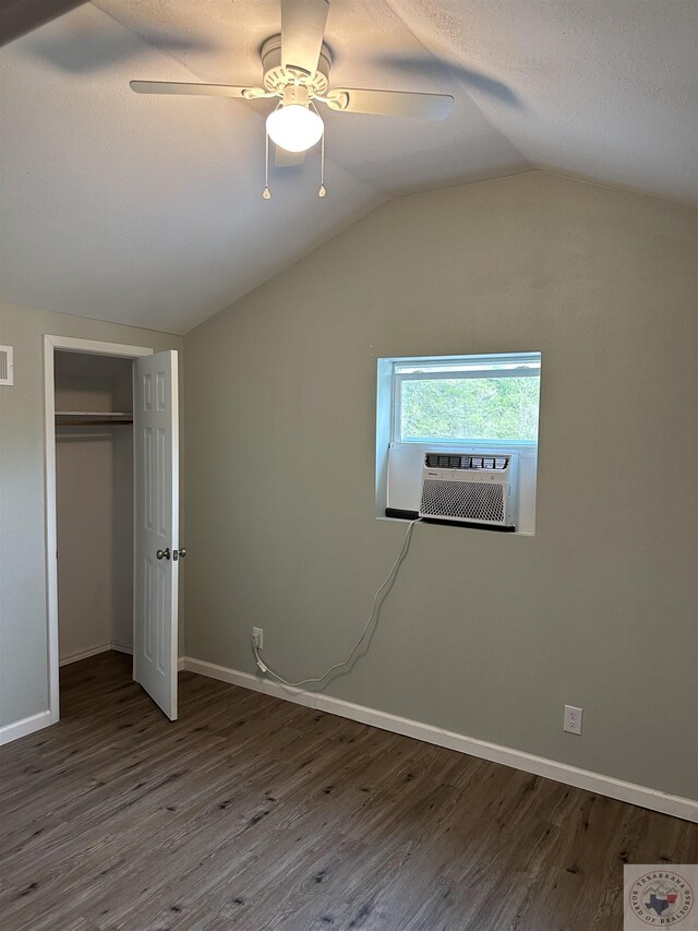 unfurnished bedroom featuring lofted ceiling, hardwood / wood-style floors, cooling unit, and ceiling fan