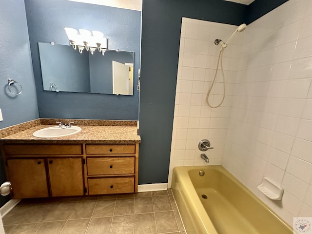 bathroom featuring tiled shower / bath, tile patterned floors, and vanity