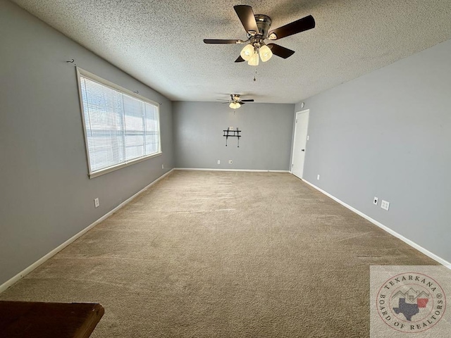 empty room featuring ceiling fan, a textured ceiling, and carpet