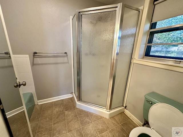 bathroom featuring tile patterned floors, plus walk in shower, and toilet