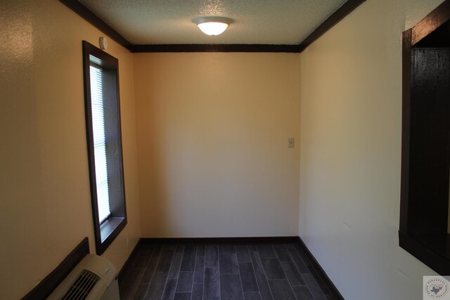 spare room featuring a textured ceiling and ornamental molding