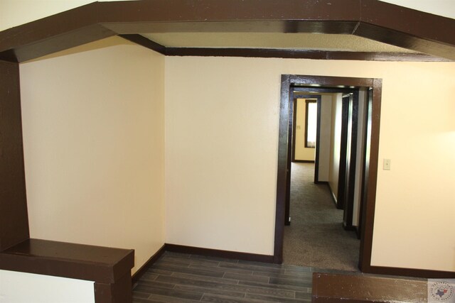 hall featuring beam ceiling and dark hardwood / wood-style flooring