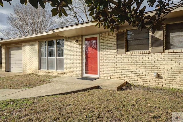 property entrance with a garage and a yard