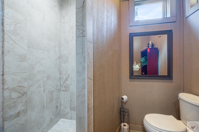 bathroom featuring toilet and tiled shower