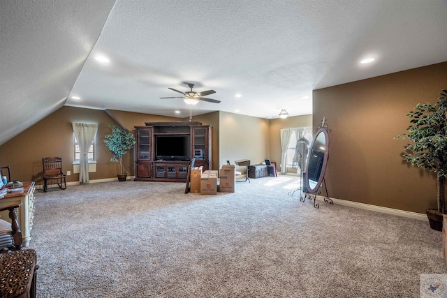 living room featuring plenty of natural light, a textured ceiling, vaulted ceiling, and carpet