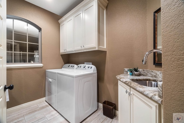 laundry room featuring sink, cabinets, and washing machine and dryer