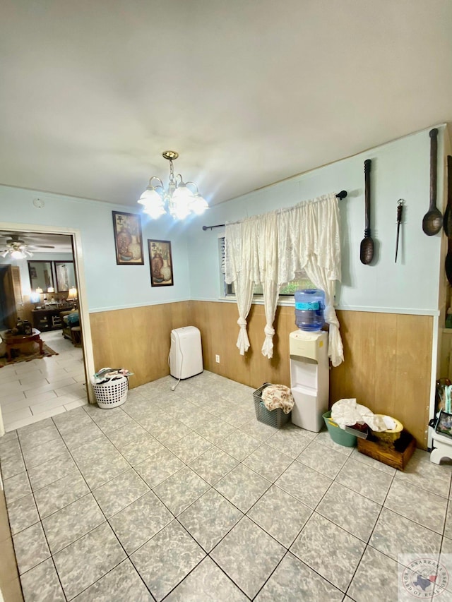 bathroom featuring ceiling fan with notable chandelier, wood walls, and tile patterned floors