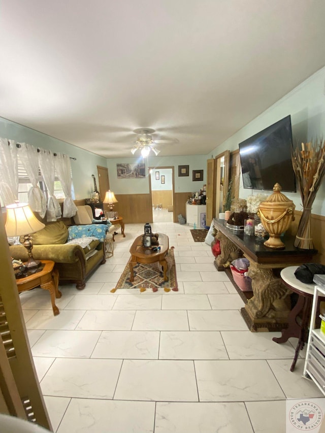 living room featuring ceiling fan and wooden walls