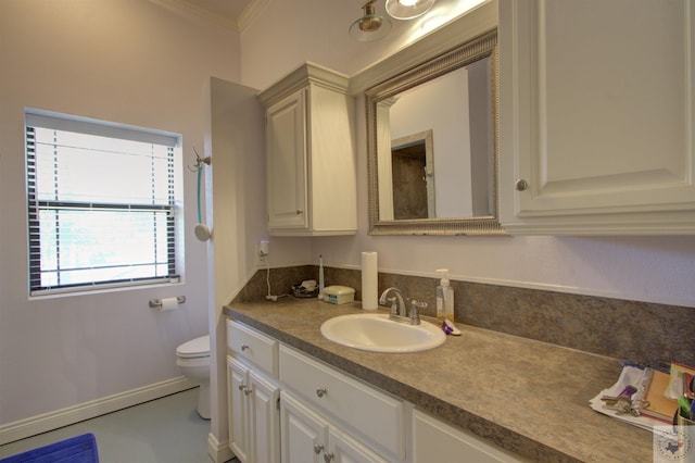 bathroom featuring toilet, vanity, and crown molding