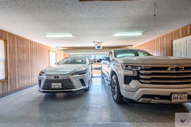 garage featuring wood walls and a garage door opener