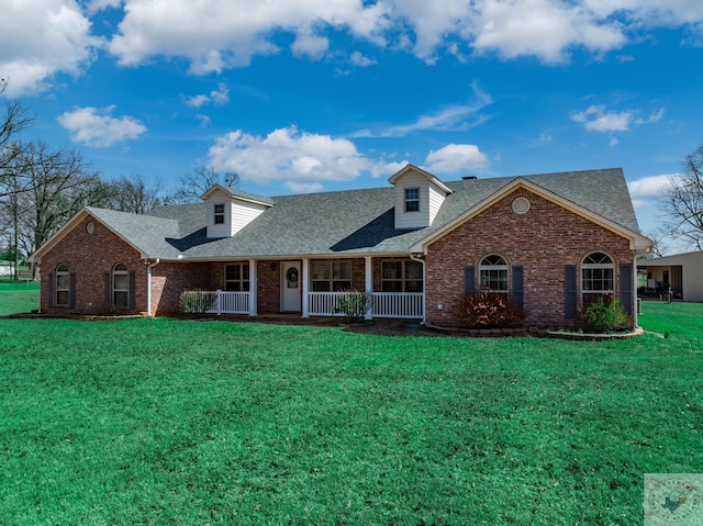 cape cod home with brick siding, a porch, a shingled roof, and a front lawn