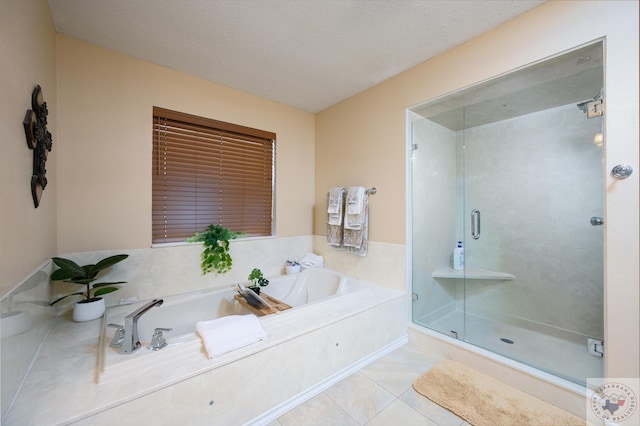 bathroom featuring a textured ceiling, a bath, a shower stall, and tile patterned flooring