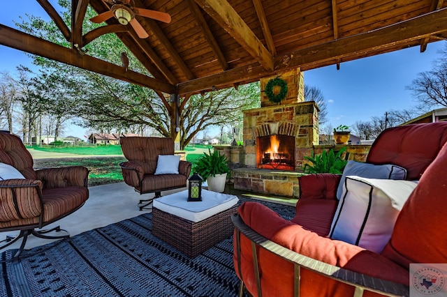 view of patio / terrace with a gazebo, ceiling fan, and an outdoor living space with a fireplace