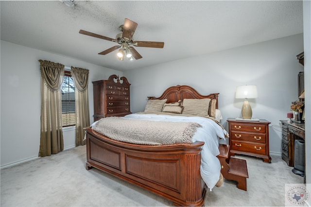 bedroom with light carpet, a textured ceiling, and a ceiling fan