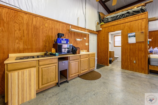 kitchen featuring concrete floors, brown cabinetry, and light countertops