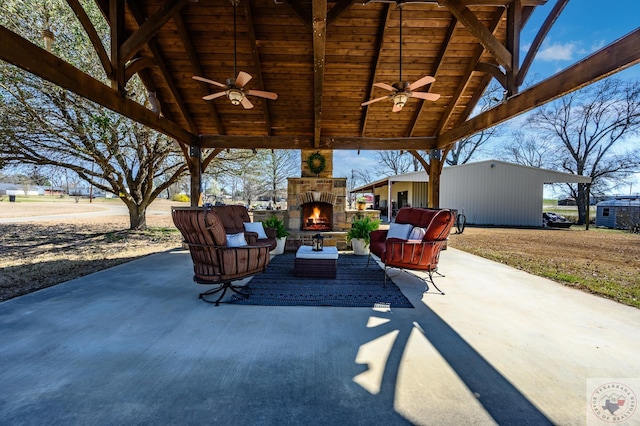 view of patio / terrace featuring an outdoor living space with a fireplace and ceiling fan