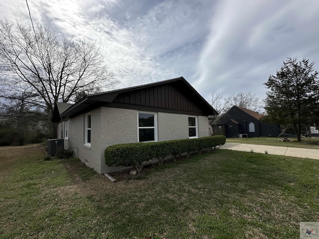 view of side of home with a lawn and central AC