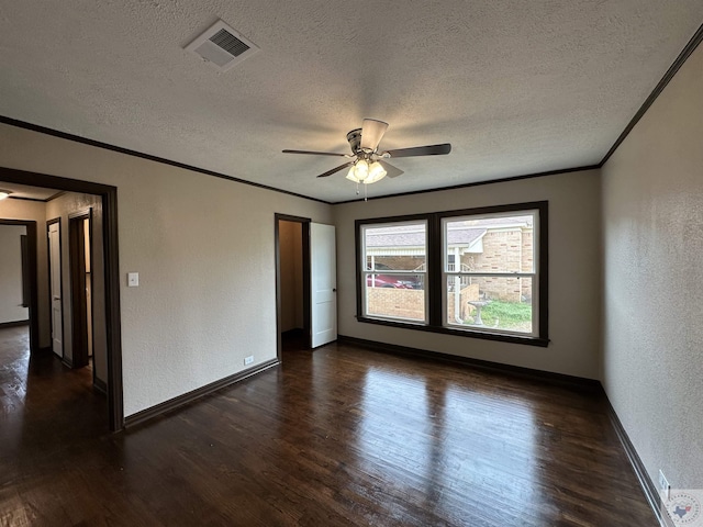 spare room featuring ceiling fan, ornamental molding, dark wood-type flooring, and a textured ceiling