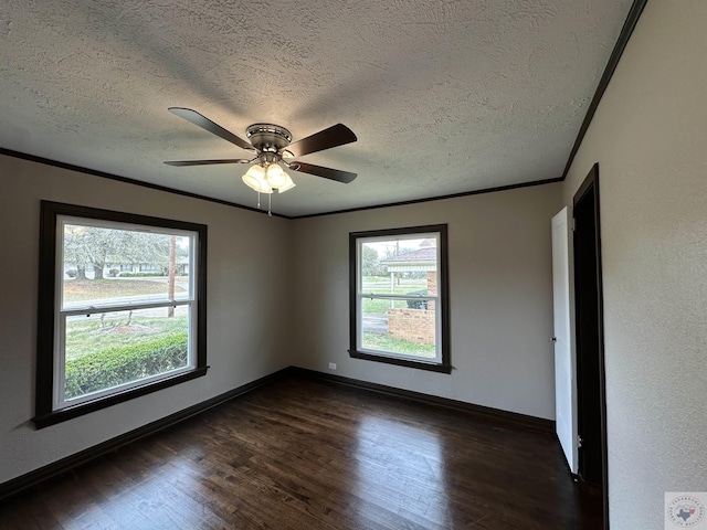 empty room featuring ceiling fan, dark wood-type flooring, a textured ceiling, and ornamental molding