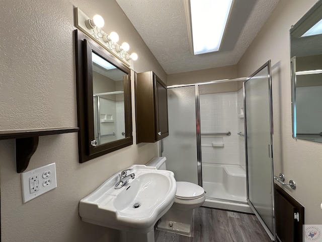 bathroom with sink, hardwood / wood-style flooring, a textured ceiling, and an enclosed shower