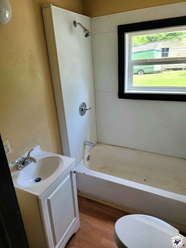 501 S Columbia St, Clarksville, TX 75426 - bathroom featuring wood finished floors,  shower combination, vanity, and toilet