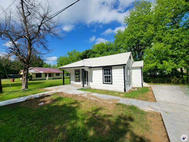 501 S Columbia St, Clarksville, TX 75426 - view of front of house featuring a front lawn, metal roof, and covered porch